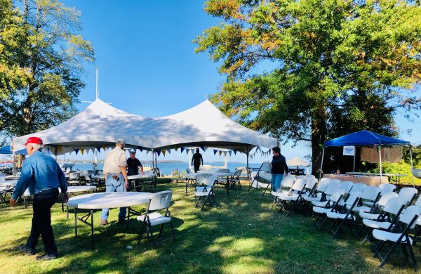 Outdoor event setup with tents and chairs on a sunny day.