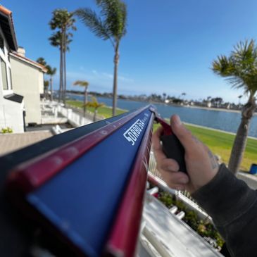 Person holding a Sorbo window squeegee overlooking a waterfront.