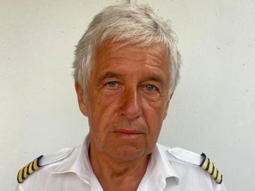Portrait of a man in a white uniform with captain's epaulets.