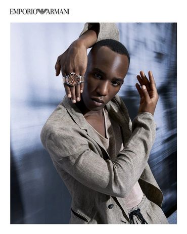 Fashion model showcasing an Emporio Armani watch and stylish beige outfit.