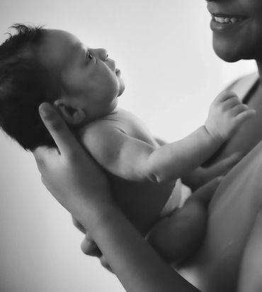 A closeup image of a mothers profile as she nuzzles in close to her newborn during a photo session, 