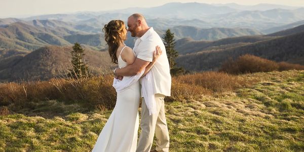 Bride and groom share first kiss with the Appalachian Mountains behind them during their Roan Mounta