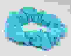 A mint blue green handmade scrunchie placed on an all white background. 