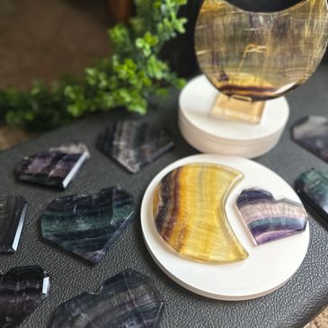yellow fluorite moon carvings displayed with candy fluorite geometric hearts 
