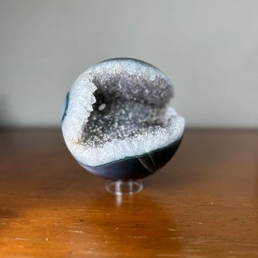 beautiful statement sphere on wood table features agate and white quartz with calcite formations