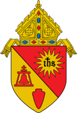 Ecclesiastical coat of arms with a bishop's mitre and religious symbols.