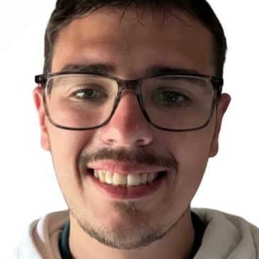 Close-up of a smiling young man wearing glasses and a white hoodie.