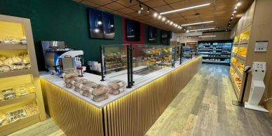 Modern grocery store interior with wooden accents and well-lit display counters.
