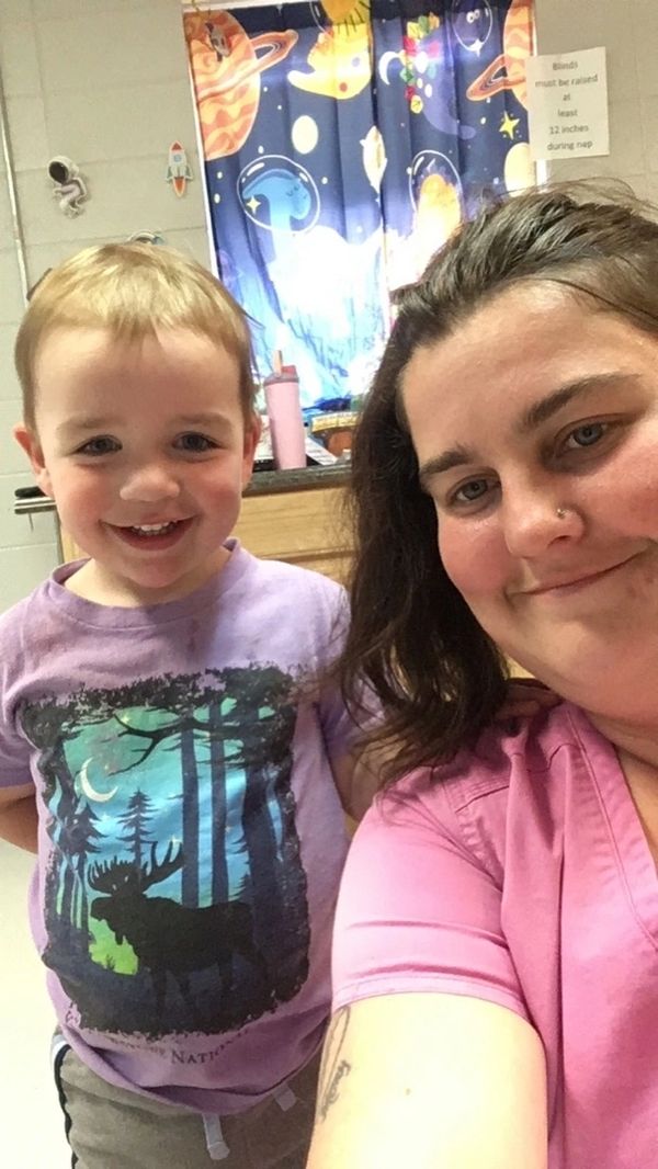 Smiling woman and young boy in a colorful room with space-themed curtains.
