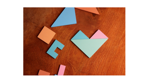 Colorful geometric wooden shapes on a wooden surface.