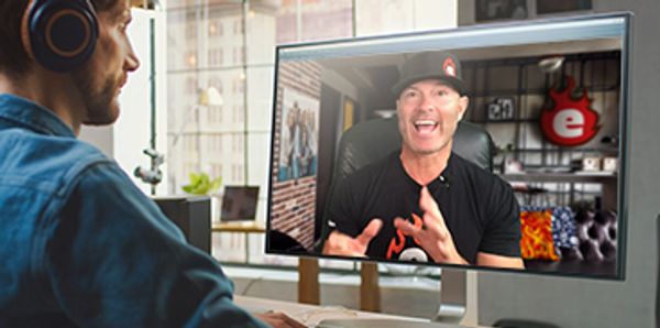 Man video chatting with a person on a computer screen.
