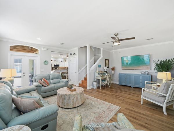 Bright living room with blue-gray sofas and wooden flooring.