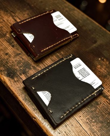 Two leather wallets with visible receipts on a wooden surface.