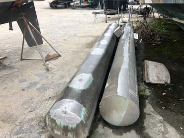 Two large metal cylindrical objects lying on the ground.