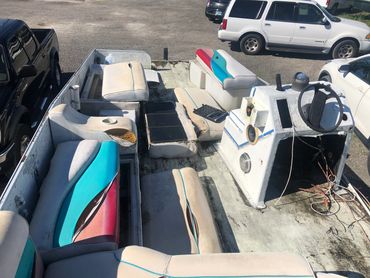 Worn interior of a boat with colorful seats.