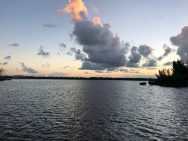 Calm water under a cloudy sky at sunset.
