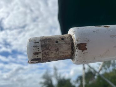 Close-up of weathered white metal pipe or railing end.