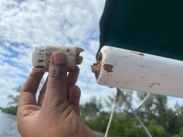 Hand holding a broken white cylindrical object.