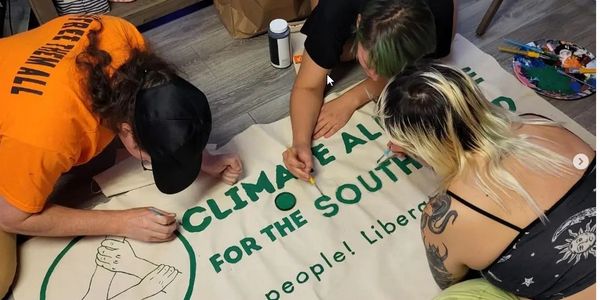 Members of the Climate Alliance of the South Sound paint the official banner.