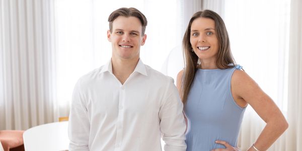 Professional young man and woman smiling indoors.