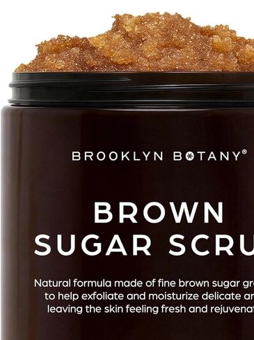 Close-up of a brown sugar scrub in a dark jar.