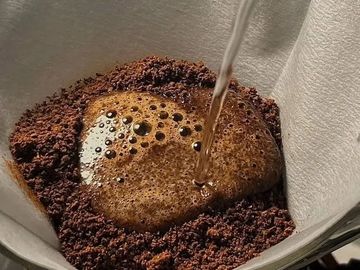 Hot water pouring over coffee grounds in a filter.