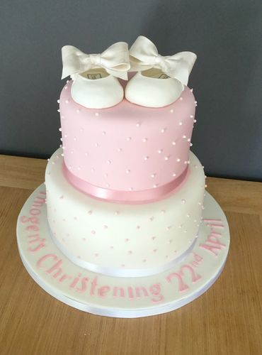 Two tiered christening cake with shoe cake topper