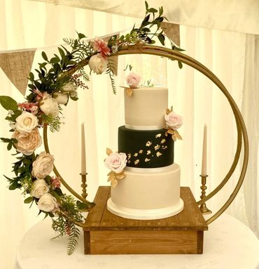 Navy and ivory wedding cake with gold leaf embellishments and pink sugar roses 
