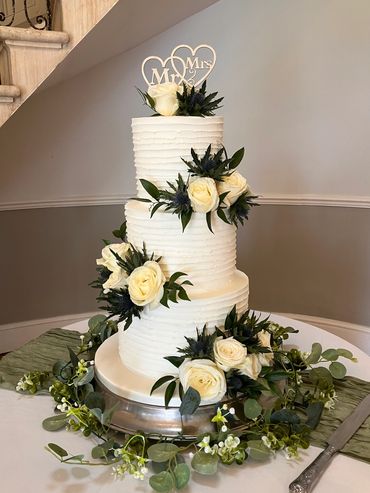 3 tiered wedding cake with white roses and sea thistles