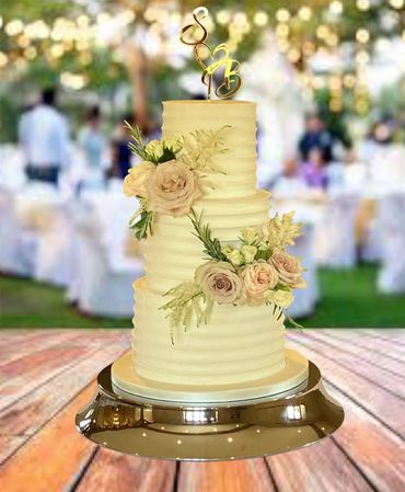 3 tiered scalloped buttercream cake with fresh flowers 