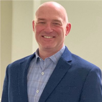 AJ Schneider in a blue blazer and light blue shirt.