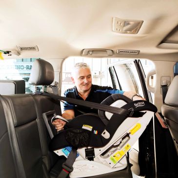 Man installing a car seat in a vehicle.