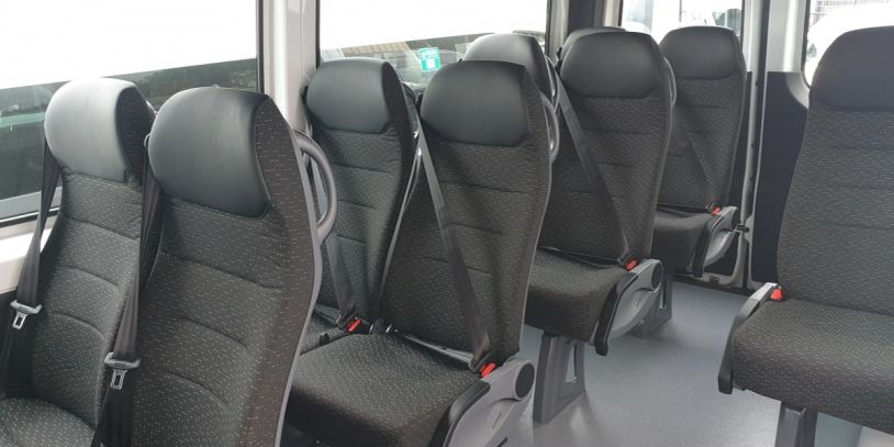 Interior of a vehicle with empty black passenger seats.