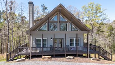 A big custom built chalet house with large wrap around porches on a full basement with big windows