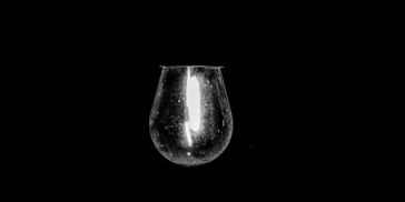 Single light bulb glowing in darkness.