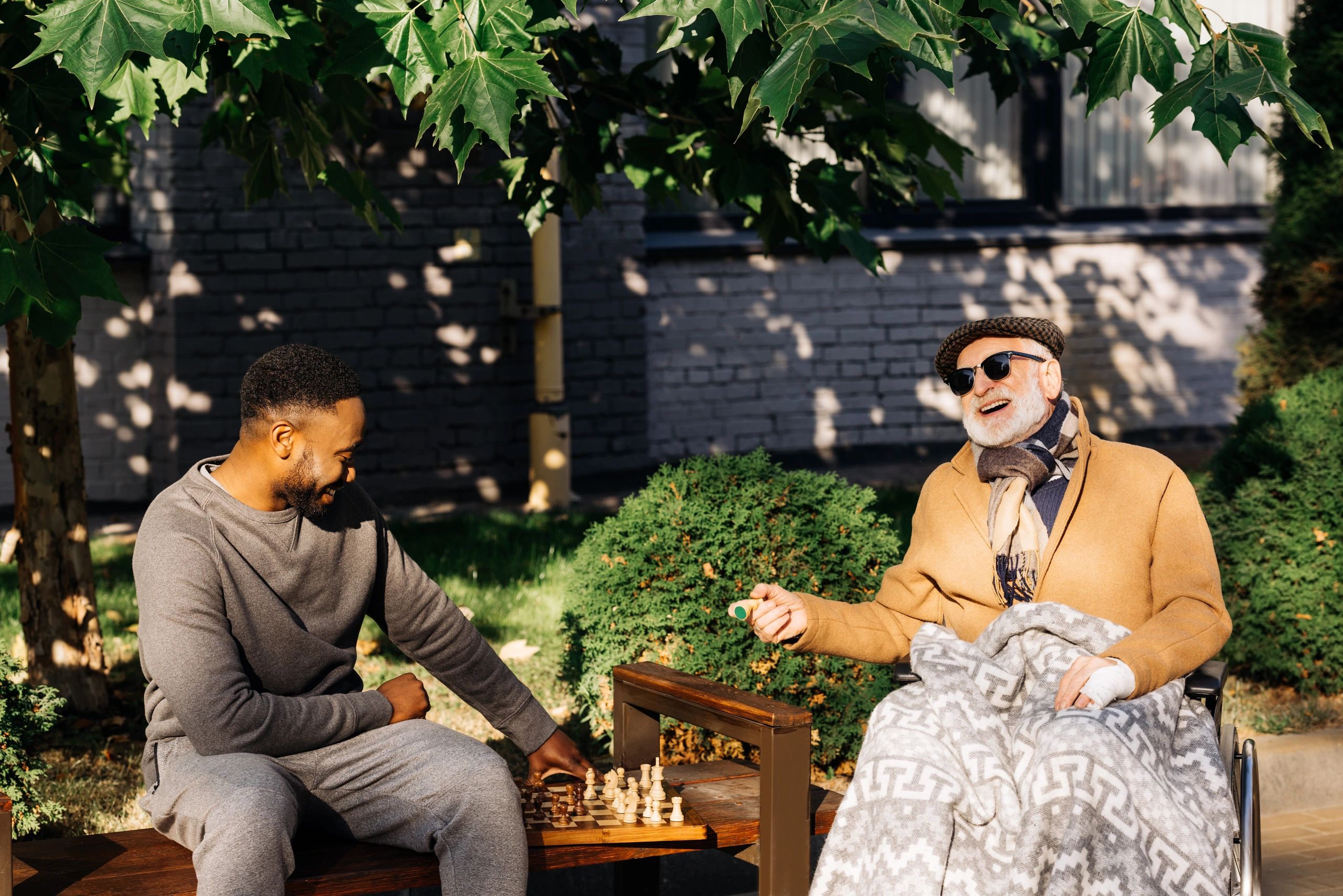 Elderly man playing chess with caregiver 