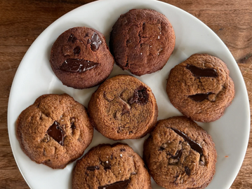Plate of freshly baked chocolate chip cookies with gooey chocolate chunks.