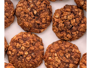 Close-up of freshly baked oatmeal cookies on a white surface.