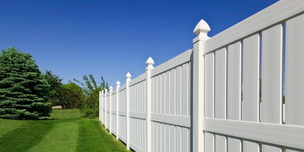 white picket fence in a well maintained backyard with an exceptionally healthy lawn.
