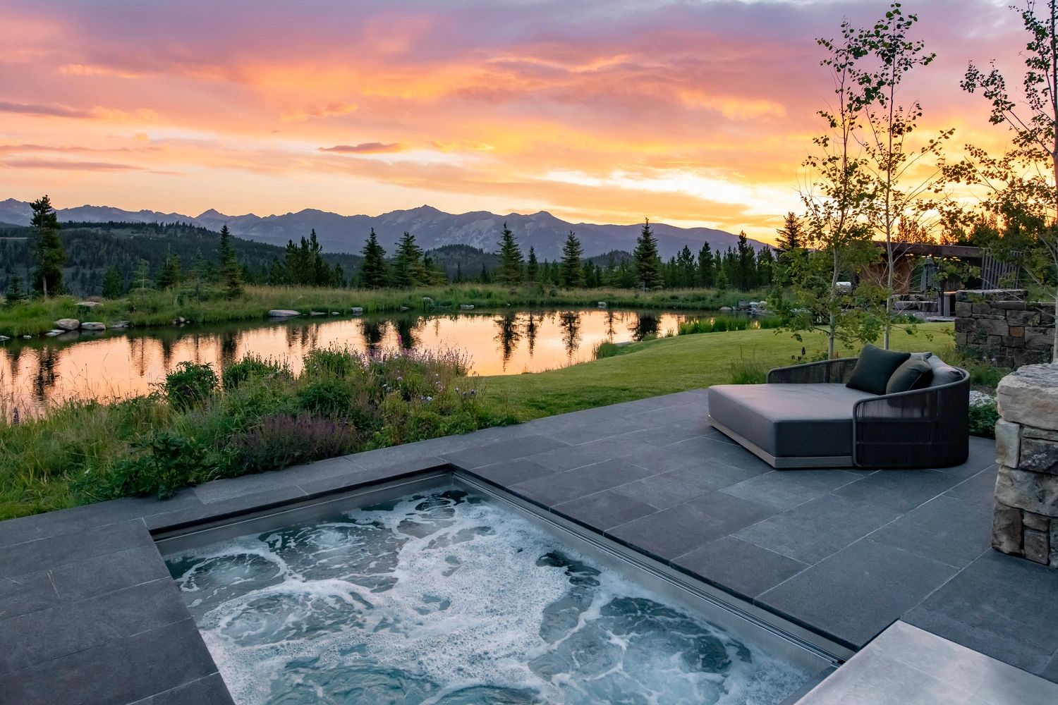 Luxury outdoor hot tub with mountain sunset view.