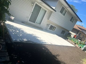 Freshly poured concrete patio in a backyard.