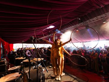Performers with hoops on stage in front of an audience.