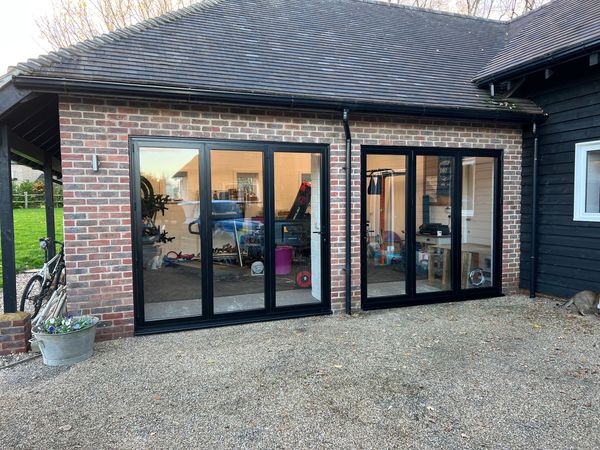 Black bi-folding doors in brick house 