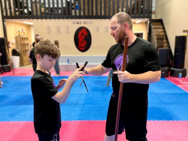 Martial arts student practicing Sai handling and control during weapons training in Moose Jaw
