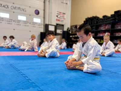 Kids Taekwondo class in Moose Jaw practicing flexibility and focus at Douglas Martial Arts.