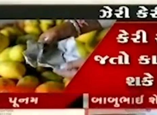 A hand cleaning fruits with a cloth, shown in a Gujarati news broadcast.