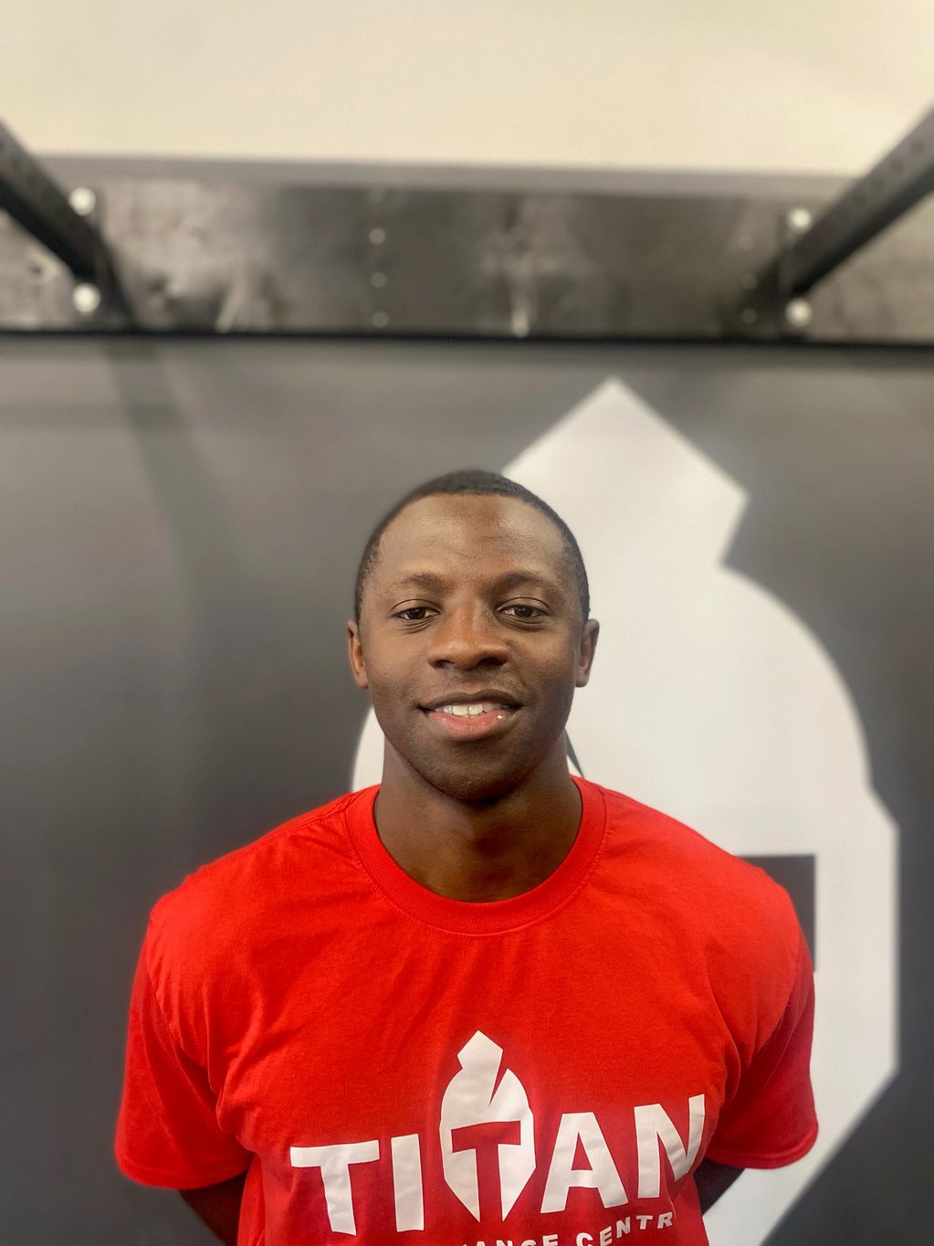 Coach Ibrahim Fofana smiling in a red Titan t-shirt