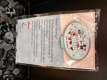 Disneyland 2022 holiday-themed Mickey and Minnie pin with a festive greeting letter.