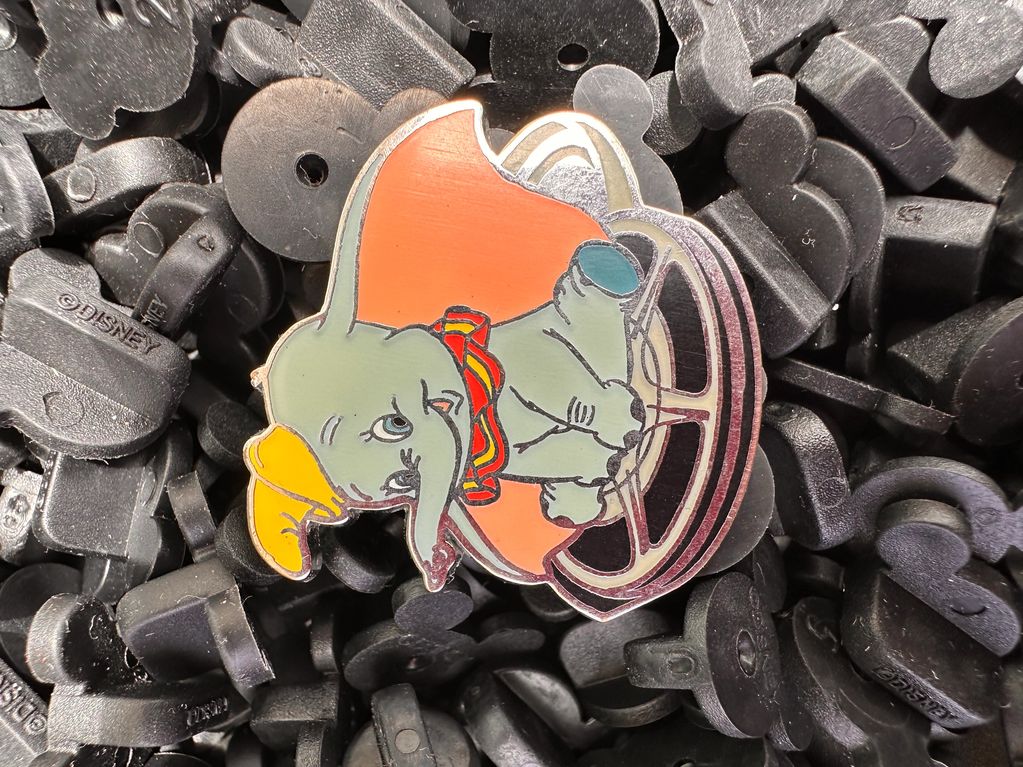 Pin of Dumbo on black plastic pieces.