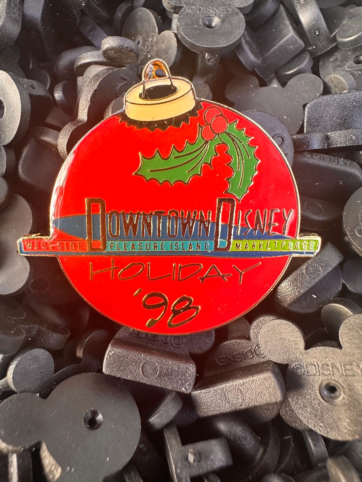 Holiday '98 Downtown Disney pin with holly decoration.